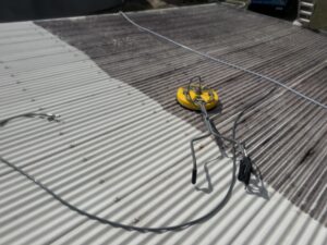 Professional roof cleaning in progress on white Colorbond roof in Mackay