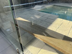 Glass pool fence cleaned during exterior cleaning service in Glenella