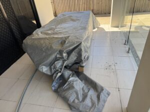 Outdoor furniture protected during house washing in Glenella