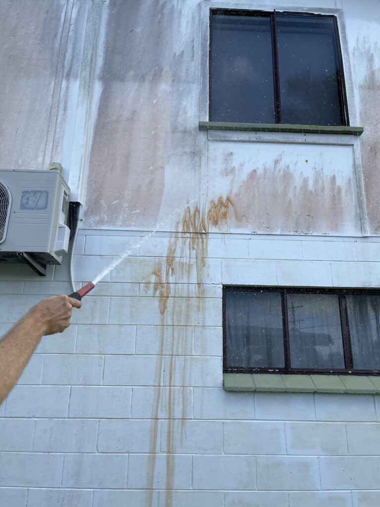 Close up of mould and exterior wall staining during house washing in Mackay