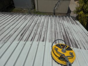 Low pressure roof washing being carried out on a Colorbond roof in Glenella