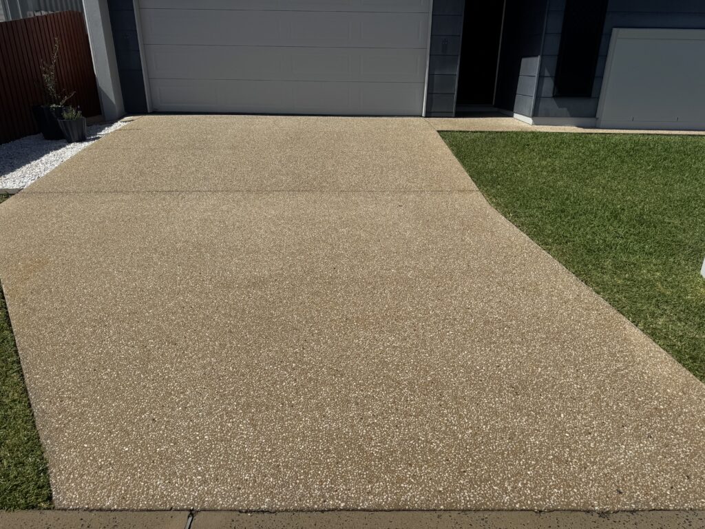 Clean exposed aggregate driveway leading to a double garage in Rural View.