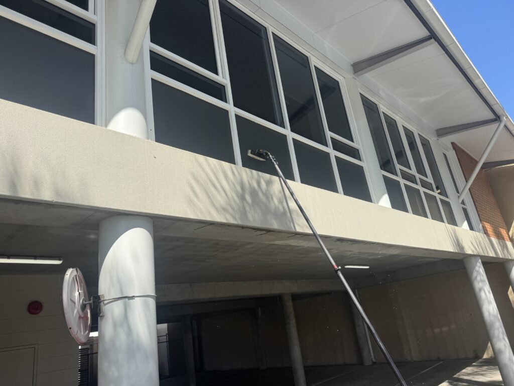 Upper office windows being cleaned with long-reach equipment in Mackay