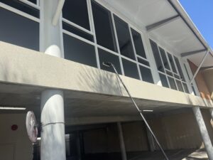 Upper office windows being cleaned with long-reach equipment in Mackay
