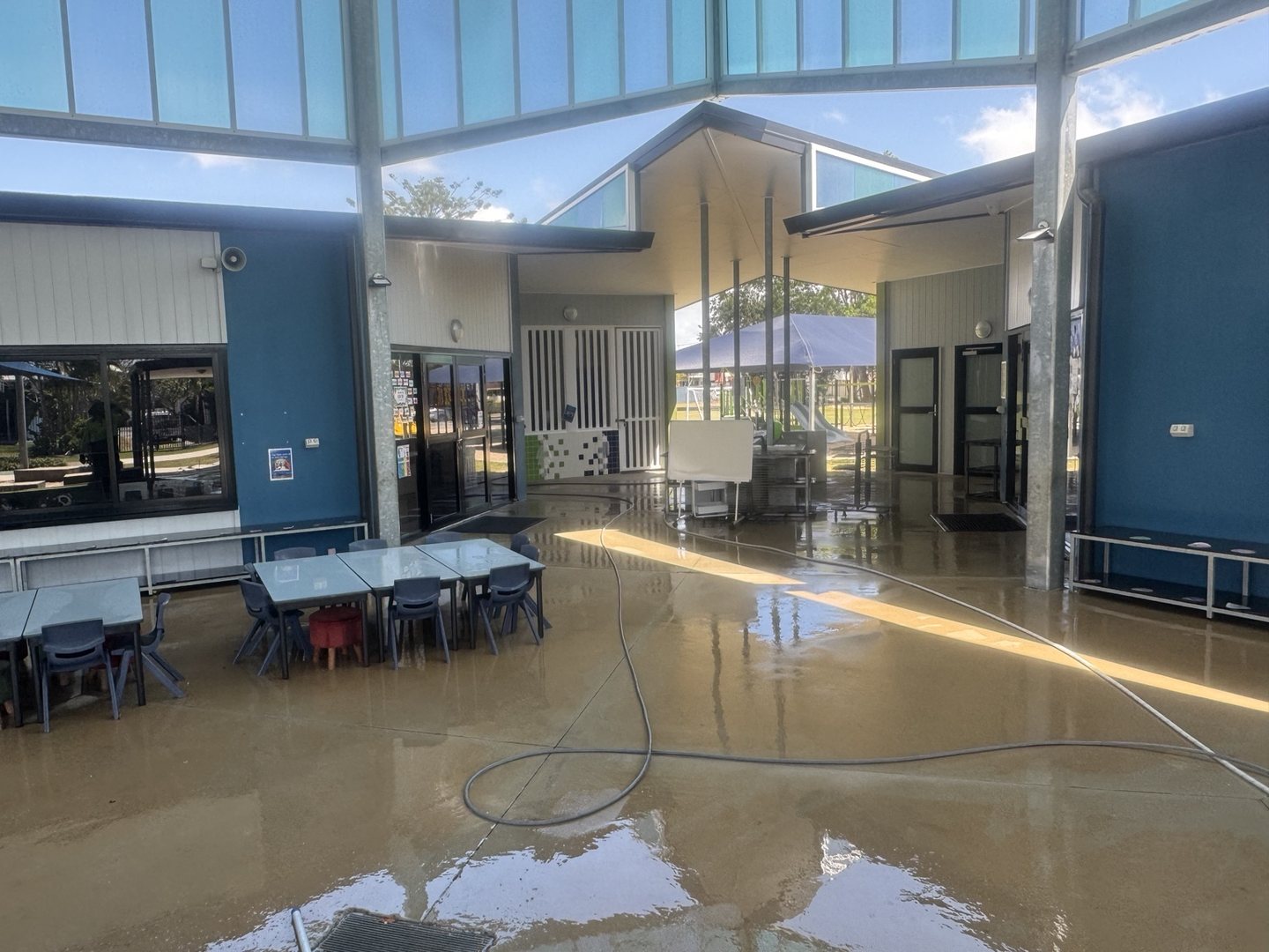 Covered area with blue walls and cleaning hoses at St Mary's school