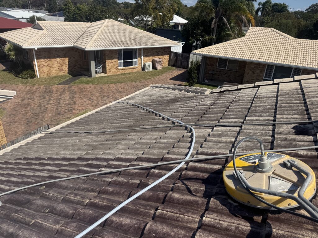 Whirlaway surface cleaner and hoses on heavily darkened painted roof tiles in West Mackay