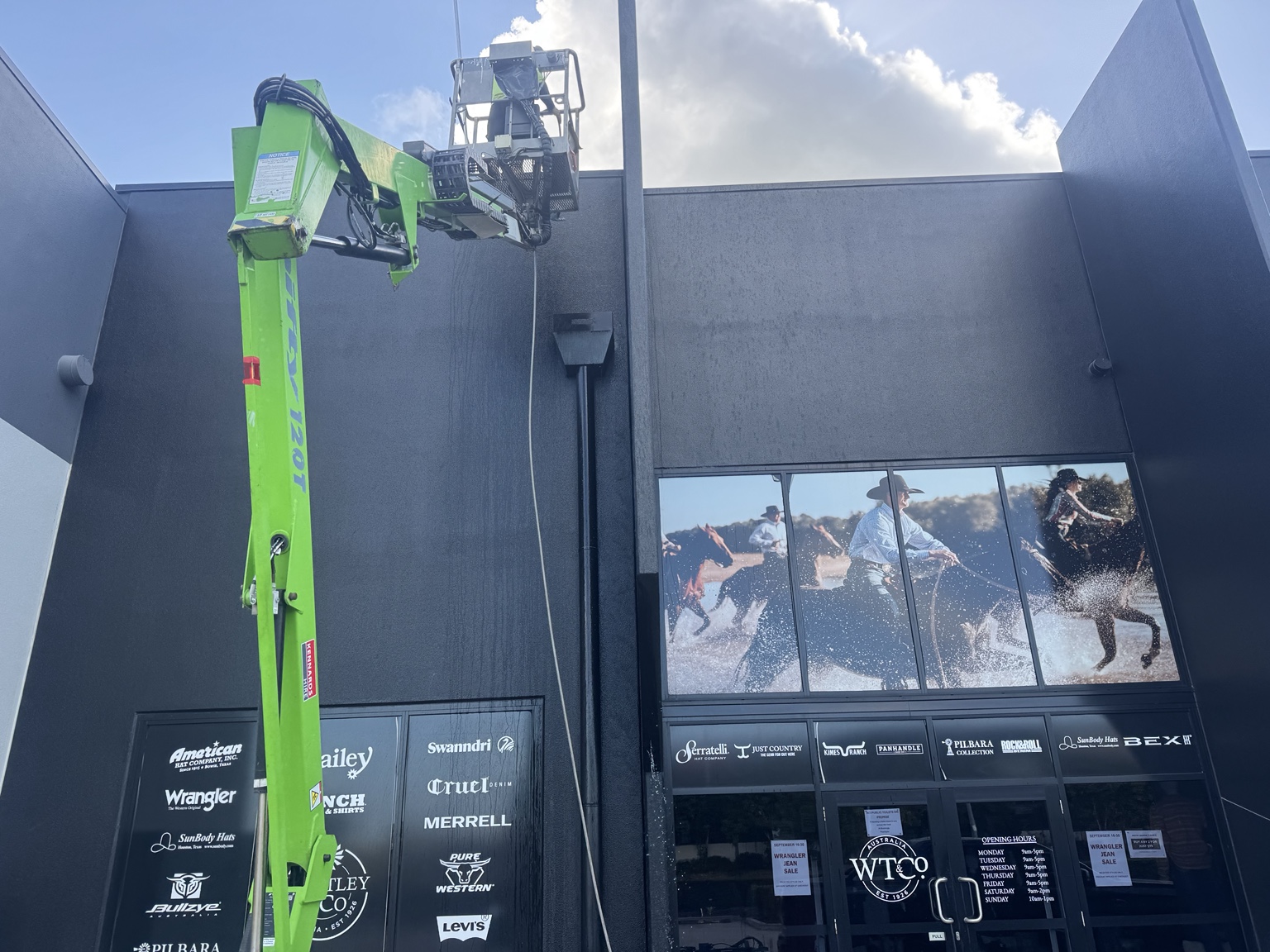 Elevated work platform positioned beside the tall shopfront walls in Mackay