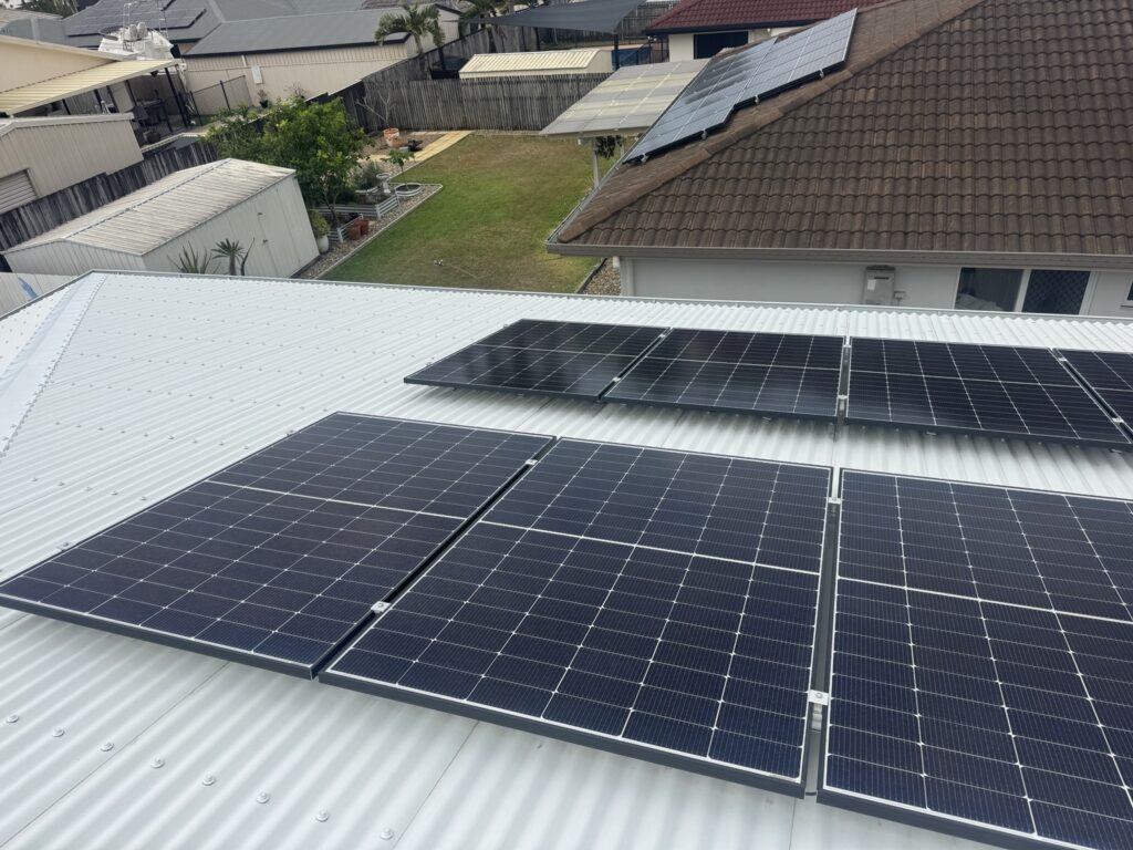 Solar panels across a cleaned metal roof in Glenella, showing the layout to consider for roof cleaning access