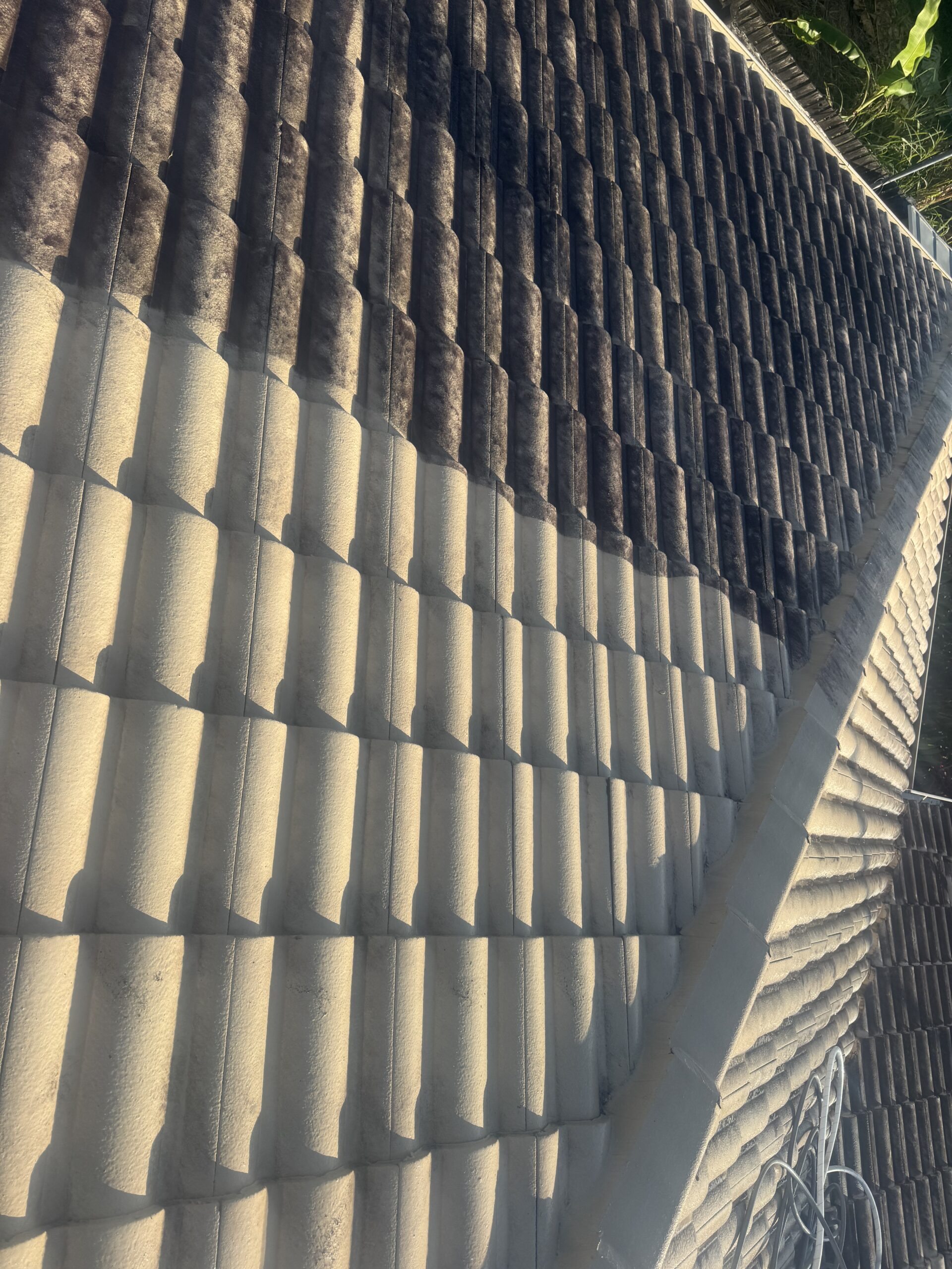 Cleaned and uncleaned painted tiles in West Mackay, showing roof condition to consider in roof cleaning quotes