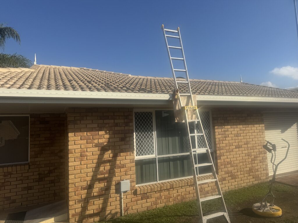 Ladder beside a brick building with a tiled roof and a Whirlaway on the ground
